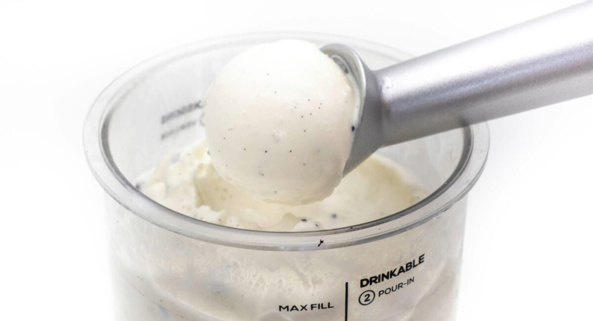 Kugel Vanilleeis ohne Zucker aus der Ninja Creami mit Portionierer über dem Becher